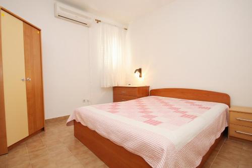a bedroom with a bed and a dresser and a window at Apartments by the sea Lumbarda, Korcula - 9263 in Lumbarda