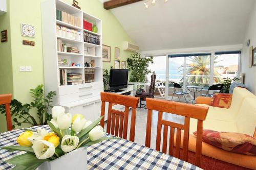 a living room with a table with flowers on it at Apartments by the sea Korcula - 9217 in Korčula