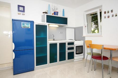 a kitchen with a blue refrigerator and a table at Apartments and rooms by the sea Korcula - 9267 in Korčula