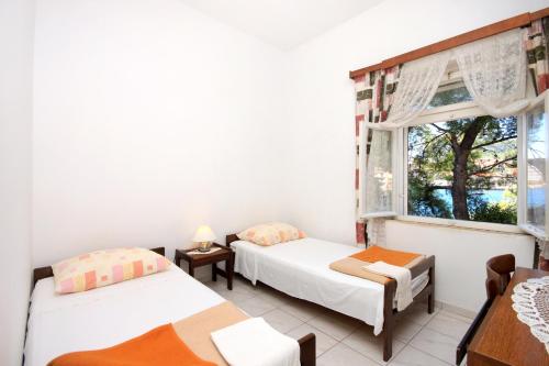 due letti in una stanza con finestra di Apartments by the sea Brna, Korcula - 9275 a Brna