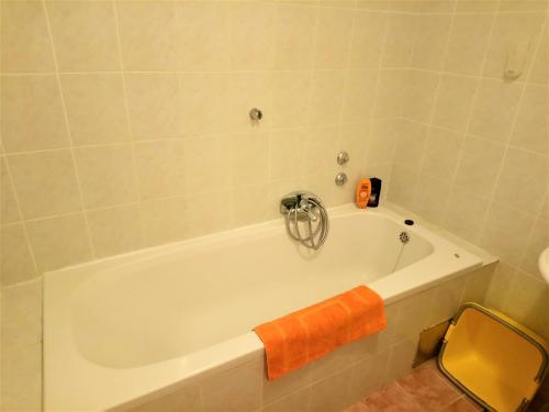 een wit bad met een oranje handdoek erop bij Apartments with a parking space Icici, Opatija - 7860 in Ičići