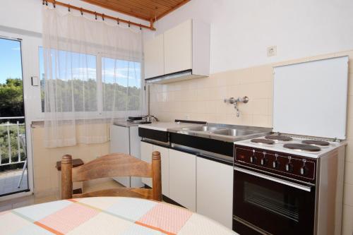 una cucina con fornelli, lavello e tavolo di Rooms with a parking space Lumbarda, Korcula - 9299 a Lumbarda (Lombarda)