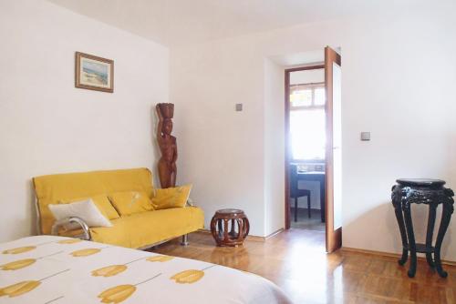 a living room with a yellow couch and a table at Apartment Veli Losinj 8029b in Veli Lošinj