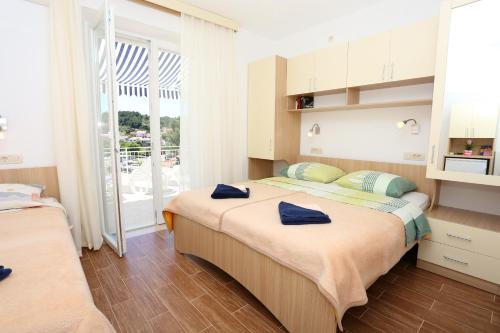 sypialnia z 2 łóżkami i niebieskimi ręcznikami w obiekcie Apartments and rooms by the sea Lumbarda, Korcula - 9305 w mieście Lumbarda