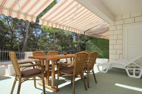 a wooden table and chairs on a patio at Apartments by the sea Lumbarda, Korcula - 9304 in Lumbarda