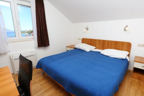 a bedroom with a blue bed and two windows at Apartments by the sea Lumbarda, Korcula - 9304 in Lumbarda