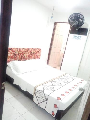 a small bed in a room with a door at montecarlos hotel in Ibagué