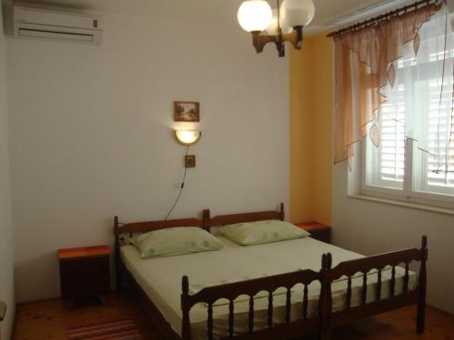 a bedroom with a bed and a window with a light at Apartments and rooms by the sea Sumartin, Brac - 2953 in Sumartin