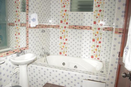 a bathroom with a bath tub and a sink at Hotel Dubai in Manizales