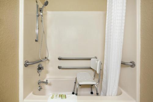 a bathroom with a shower and a toilet at Super 8 by Wyndham Fairview Heights-St. Louis in Fairview Heights