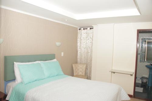 a bedroom with a bed with a white and blue at Hotel Dubai in Manizales