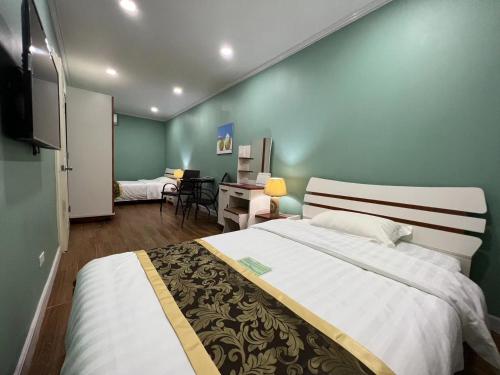 a bedroom with a large bed and a desk at Beach Garden Hotel in Saipan