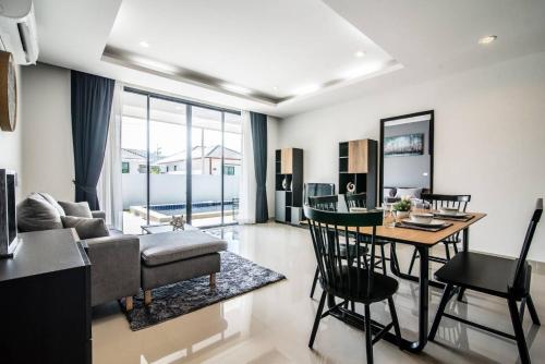 a living room with a table and a dining room at 2 Bed Contemporary Pool Villa in Hua Hin