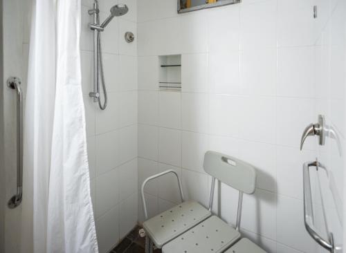 a bathroom with a shower with a bench in it at Hotel El Remanso Tapalpa in Tapalpa