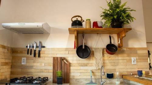 una cocina con ollas y sartenes en la pared en Maravista Kite Hostel Preá, en Prea