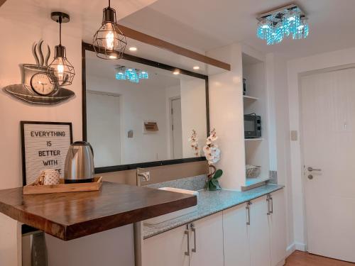 a kitchen with a sink and a mirror at GoldenSuites at CoolSuites WindResidences Tagaytay in Tagaytay