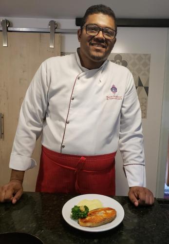 a man standing in a kitchen with a plate of food at Pousada Tekoá Indiana in Cachoeiras de Macacu