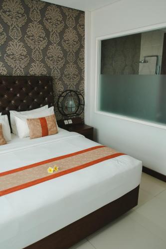 a bedroom with a large bed with a large window at The Visala Boutique Suites Seminyak in Seminyak