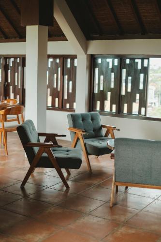 a room with chairs and tables and windows at The Visala Boutique Suites Seminyak in Seminyak