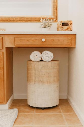 a bathroom counter with two towels on a stool under a sink at Puamana Maluhia - Two Bedroom / Two Bath Condo in Princeville