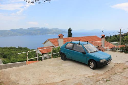 a small blue car parked in front of a house at Holiday house with a swimming pool Zagore, Opatija - 7922 in Zagorje