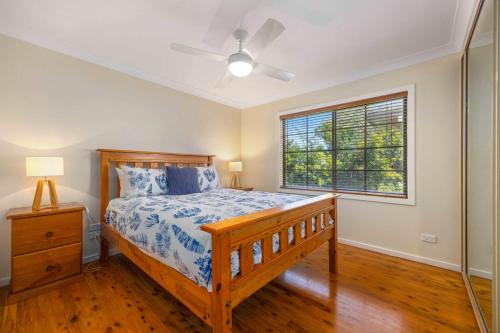 a bedroom with a bed and a window at Little Beach Bungalow - at Bartlett's in Bonny Hills