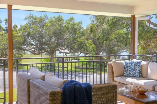 a screened porch with two couches and a table at Little Beach Bungalow - at Bartlett's in Bonny Hills