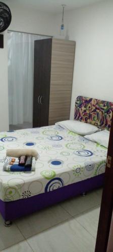 a bedroom with a bed with a white and blue comforter at montecarlos hotel in Ibagué