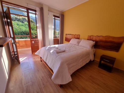 a bedroom with a bed and a large window at Pampa Bella Lodge in La Merced