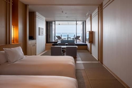 a hotel room with two beds and a living room at Pearl Star Hotel ATAMI in Atami