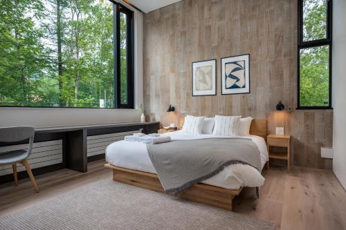 a bedroom with a large bed with a desk and windows at Ryoun by H2 Life in Niseko