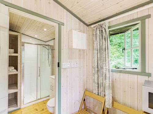 a bathroom with a toilet and a window at Lakeside Cabin in Dunkeswell