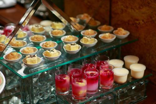 una vitrina llena de diferentes tipos de postres en Babylon Grand Hotel & Spa, en Hanói