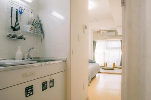 een keuken met een wastafel en een slaapkamer met een bed bij Shinjuku-Kabukicho-507 in Tokyo