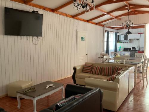 sala de estar con sofá y TV en la pared en Hostal Viña Del Mar en Taltal