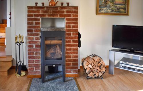 a brick fireplace with a stove in a living room at Amazing Home In Hagalundmjölby in Mjölby