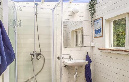 a white bathroom with a sink and a shower at Amazing Home In Hagalund-mjlby With Wifi in Mjölby