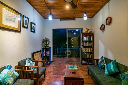 a living room with two couches and a coffee table at Mistletoe Homestay & Cafe in Munnar