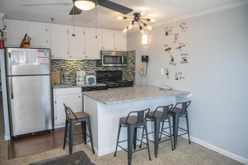a kitchen with a white refrigerator and bar with stools at Stroll to Slopes, Village Area, Ski in-out MtLodge 269 in Snowshoe