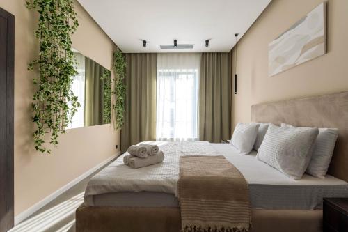 Lazy Seal Holiday Cottages Nabran في Müqtǝdir: غرفة نوم بسرير كبير عليها نبات على الحائط