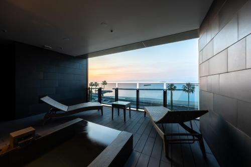 a room with a balcony with a view of the ocean at Pearl Star Hotel ATAMI in Atami