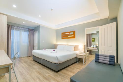 a hotel room with a large bed and a desk at Koon Hotel Sukhumvit in Bangna