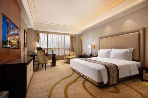 a hotel room with a large bed and a desk at Shenzhen Baolilai International Hotel (Baoan, Fuyong) in Bao'an