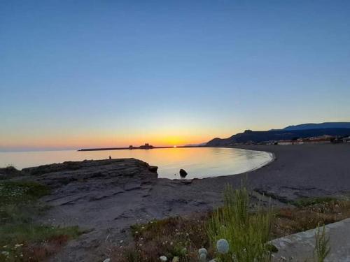 un tramonto su un corpo d'acqua con il tramonto di Le Camelie camera a Bosa