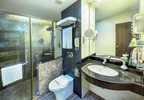 a bathroom with a sink and a toilet and a shower at Pearl Grand By Rathna in Colombo
