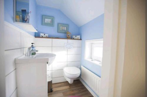 y baño con aseo blanco y lavamanos. en ,,Björklunda" cozy apartment in swedish lapland en Lycksele
