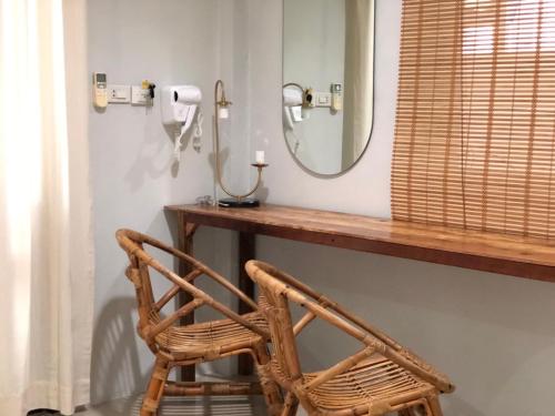 a bathroom with a mirror and a wicker chair at My home resort - ขนอม นครศรีธรรมราช in Khanom