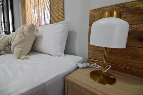 a lamp on a night stand next to a bed at My home resort - ขนอม นครศรีธรรมราช in Khanom