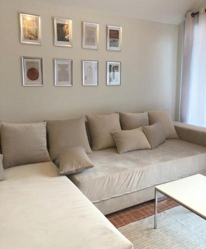a couch in a living room with pictures on the wall at My home resort - ขนอม นครศรีธรรมราช in Khanom