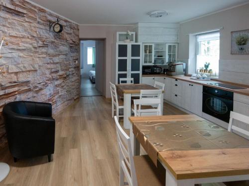 kuchnia z ceglaną ścianą oraz stołem i krzesłami w obiekcie Bokor vendégház - Levendula apartman w mieście Szentes